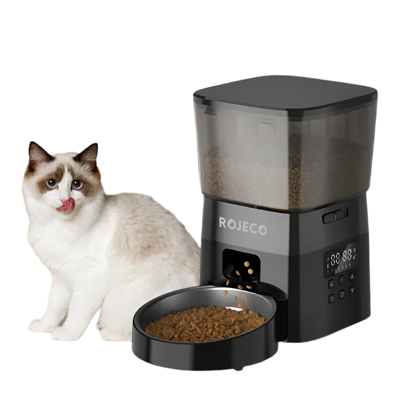 Cat sitting next to a ROJECO pet feeder on a wooden floor.